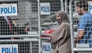 A Saudi Arabian couple stand beside barriers in front of Saudi Arabia's consulate in Istanbul on October 4, 2018.  AFP / Ozan Kose 