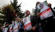 Human rights activists and friends of Saudi journalist Jamal Khashoggi hold his pictures during a protest outside the Saudi Consulate in Istanbul, Turkey October 8, 2018. (REUTERS/Murad Sezer)