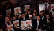 People hold posters picturing Saudi journalist Jamal Khashoggi as they gather outside the Saudi Arabia consulate in Istanbul, on October 25, 2018 during a demonstration. Jamal Khashoggi, a Washington Post contributor, was killed on October 2, 2018 after a