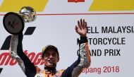 Repsol Honda Team Spanish rider Marc Marquez celebrates on the podium with the trophy after winning the Malaysia MotoGP at the Sepang International Circuit in Sepang on November 4, 2018. / AFP / Mohd RASFAN 