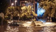 People are having fun with a boat on the flooded main road of the Daeya area of Kuwait city late on November 14, 2018, following heavy rain in the Gulf emirate, four days after flash floods hit the Gulf emirate, killing a man and causing damage to roads, 