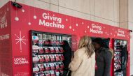 Sister Hicks (C) assists a woman in making a donation at a Giving Machine November 29, 2018 in New York. At right is Sister Davis. AFP / Don Emmert 