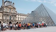  In this file photo taken on July 02, 2015 tourists and visitors queue outside the Louvre Pyramid on a hot day in Paris on July 2, 2015, as a heatwave sweeps through Europe. / AFP / Miguel MEDINA 