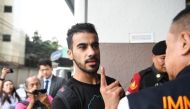 Hakeem Alaraibi (C), a former Bahrain national team footballer with refugee status in Australia, is escorted by immigration police to a court in Bangkok on December 11, 2018. / AFP / Lillian SUWANRUMPHA
 