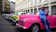 Driver Giovani Bernati waits for tourists beside vintage cars used as taxi in Havana, Cuba, October 5, 2018. Reuters/Alexandre Meneghini