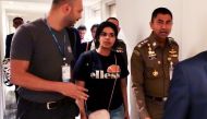 This handout picture taken and released by the Thai Immigration Bureau on January 7, 2019 shows 18-year-old Saudi woman Rahaf Mohammed al-Qanun (C) being escorted by a Thai immigration officer (R) and United Nations High Commissioner for Refugees (UNHCR) 