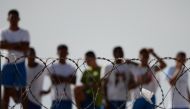 Inmates watching as injured prisoners are removed to receive medical care the day after a battle between gangs in the Alcacuz Penitentiary Center, Brazil, January 20, 2017. AFP/Andressa Anholete