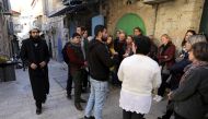 Tour guides, Noor Awad, a Palestinian from Bethlehem, and Lana Zilberman Soloway, a Jewish seminary student, speak to a group of tourists during the Dual Narrative tour they lead in Jerusalem's Old City February 4, 2019. Reuters/Ammar Awad
 