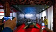 Tourists take pictures of an embalmed giant turtle displayed at Ngoc Son temple in Hanoi on March 21, 2019. AFP / Manan Vatsyayana 