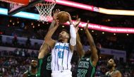 Charlotte Hornets center Willy Hernangomez (41) shoots the ball between Boston Celtics forward Daniel Theis (27) and forward Semi Ojeleye (37) in the first half at Spectrum Center. Jeremy Brevard