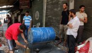 FILE PHOTO: Syrian merchats sell fuel at a market in an opposition-held district in Syrias' northern city of Aleppo on August 12, 2016. AFP