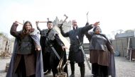 French Game of Thrones fans, Claire Pottier (L) and Hugo Chivard (2L), from Normandy, US fan Jocelyn Vadli (R) take part in axe throwing with Master of Arms Will van der Kells (2R) at the Castle Ward Estate in Strangford, northern Ireland, on April 17, 20