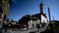 A general view taken on April 9, 2019 shows visitors walking past the Santa Croce church in Vinci, the Tuscan village where Leonardo Da Vinci was born. AFP / Filippo Monteforte 