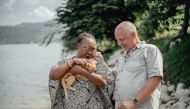 Esperance Mawanzo and Luc Henkinbrant, founders of the Esperance (Hope) Agency, play with a cat as they stand in front of their ecotourism lodge on Idjwi island, in Lake Kivu, on April 5, 2019.  AFP / Luke Dennison 