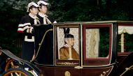 In this file photo taken on November 28, 1990 Japanese Emperor Akihito sits in a carriage on his way to visit the inner shrine at Ise.  AFP / Toshifumi Kitamura