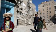 A girl carries a stack of bread on her head as she walks near rubble of damaged buildings in Aleppo's Kalasa district, Syria April 12, 2019. Picture taken April 12, 2019. REUTERS/Omar Sanadiki