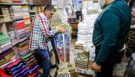 Palestinian craftsman Issam Zughair (L) moves a large Ramadan lantern in his shop in the old city of Jerusalem on May 2, 2019. AFP / AHMAD GHARABLI