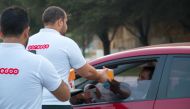 Ooredoo volunteers distributing dates and water on Doha Corniche.