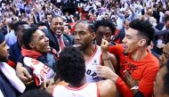 Kawhi Leonard #2 of the Toronto Raptors celebrates with teammates after sinking a buzzer beater to win Game Seven of the second round of the 2019 NBA Playoffs against the Philadelphia 76ers at Scotiabank Arena on May 12, 2019 in Toronto, Canada. AFP / Vau