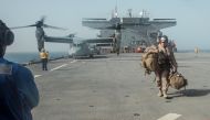 U.S. Marine Corps Gunnery Sgt. David Arendt carries his gear across the flight deck of the USS Lewis B. Puller upon embarkation in the Arabian Gulf, May 11, 2019 . Courtesy Desiree King/U.S. Marine Corps
