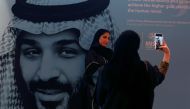 Participants take photos next to a picture of Saudi Crown Prince Mohammed bin Salman during the Misk Global Forum in Riyadh, November 14, 2018. Reuters/Faisal Al Nasser