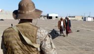 Yemenis walk past a Saudi soldier standing guard in Marib, January 26, 2018. Reuters/Faisal Al Nasser