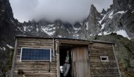 Sarah Cartier, guardian of the Charpoua refuge on the Charpoua Glacier, poses on the threshold of the refuge in Chamonix-Mont-Blanc on June 19, 2019. AFP / Marco Bertorello 