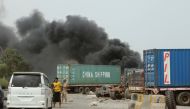 Members of UAE-backed forces stop cars on a street as smoke billows from a car service shop during clashes in Aden, Yemen August 9, 2019. (REUTERS/Fawaz Salman)