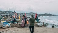 Tourists pose for pictures at the Cape Coast Castle on August 18, 2019. AFP / Natalija Gormalova 