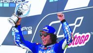 Suzuki Ecstar's Spanish rider Alex Rins holds up the trophy on the podium as he celebrates his victory in the Moto GP race of the British Grand Prix at Silverstone circuit in Northamptonshire, central England, on August 25, 2019. AFP / Adrian Dennis