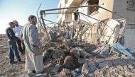 Syrian men look at a destroyed sheep pen following a reported Russian air strike in the village of al-Daher in Syria's northwestern Idlib province on September 11, 2019.  AFP / Omar HAJ KADOUR