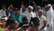 Amir HH Sheikh Tamim bin Hamad al-Thani (C) fires the staring gun for the Women's Marathon at the 2019 IAAF World Athletics Championships in Doha on September 27, 2019. AFP / Karim Jaafar 