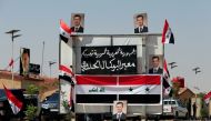 Posters of Syrian President Bashar al-Assad are seen at the Iraqi-Syrian border, after it has been reopened for trade and travel, in Al Qaim, Iraq September 30, 2019. REUTERS/Thaier Al-Sudani