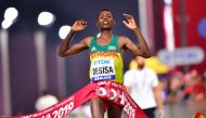 Ethiopia's Lelisa Desisa celebrates as he crosses the finish line and wins the Men's Marathon at the 2019 IAAF Athletics World Championships in Doha in the night between October 5, 2019 and October 6, 2019. / AFP / Giuseppe Cacace 