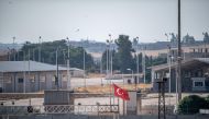 The border between Turkey and Syria, in Akcakale, Sanliurfa province, southeastern Turkey, shows a gate beytween Syria and Turkey in the Syrian town of Tel Abyad, on October 8, 2019. AFP / BULENT KILIC