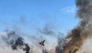 Smoke rises from the Syrian town of Tal Abyad, in a picture taken from the Turkish side of the border where a pigeon is seen in Akcakale on October 10, 2019, on the second day of Turkey's military operation against Kurdish forces.   AFP / BULENT KILIC
