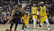 Spencer Dinwiddie of the Brooklyn Nets (L) drives the ball while is guarded by Rajon Rondo (R) of the Los Angeles Lakers during the National Basketball Association (NBA) pre-season match between the LA Lakers and Brooklyn Nets at the Mercedes Benz Arena i