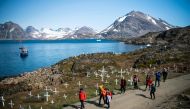 Andrea Fiocca (L), Italian researcher and tour guide leads a group of tourists as they arrive to Kulusuk (also spelled Qulusuk), a settlement in the Sermersooq municipality located on the island of the same name on the southeastern shore of Greenland on A