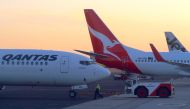 FILE PHOTO: Workers are seen near Qantas Airways, Australia's national carrier, Boeing 737-800 aircraft on the tarmac at Adelaide Airport, Australia, August 22, 2018. REUTERS/David Gray/File Photo