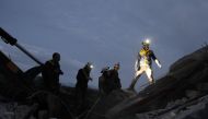 Members of the Syrian Civil Defence, also known as the White Helmets, search for survivors following an air-strike on the flashpoint town of Maaret al-Numan in Syria's southern Idlib governorate on December 30, 2019. / AFP / Abdulaziz KETAZ