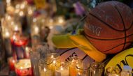 Candles are displayed at a makeshift memorial in front of a mural for former NBA and Los Angeles Lakers player Kobe Bryant in downtown Los Angeles on January 26, 2020, as people pay tribute to the former basketball player following his death in a helicopt