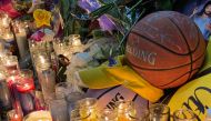 Candles are displayed at a makeshift memorial in front of a mural for former NBA and Los Angeles Lakers player Kobe Bryant in downtown Los Angeles on January 26, 2020 as people pay tribute to the former basketball player following his death in a helicopte