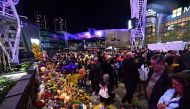 People gather in front of a makeshift memorial for former NBA and Los Angeles Lakers player Kobe Bryant and his daughter Gianna Bryant, who were killed with seven others in a helicopter crash on January 26, at LA Live plaza in front of Staples Center in L