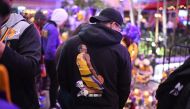 People gather in front of a makeshift memorial as they mourn the death of NBA legend Kobe Bryant at LA Live plaza in front of Staples Center in Los Angeles on January 27, 2020.   AFP / Robyn Beck