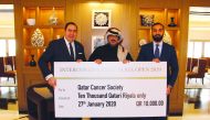 Officials handing over the cheque to Qatar Cancer Society at the Inter-Continental Doha Hotel & Residences.