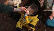 An internally displaced man pinches the cheek of a child wearing socks with a hole at a makeshift camp in Azaz, Syria February 19, 2020. Reuters/Khalil Ashawi
 