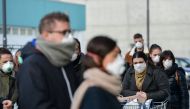 Residents wearing respiratory mask wait to be given access to shop in a supermarket in small groups of forty people on February 23, 2020 in the small Italian town of Casalpusterlengo, under the shadow of a new coronavirus outbreak, as Italy took drastic c