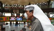 A Kuwaiti trader wears a protective face mask, following the outbreak of the new coronavirus, as he stands on the upper floor since the lower main hall is closed to traders at the Kuwait Boursa stock market trading in Kuwait city, Kuwait, March 1, 2020. R