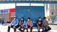 People wearing protective masks wait at a bus station in Kuwait City on March 2, 2020, amid a global outbreak of the novel Coronavirus. / AFP / YASSER AL-ZAYYAT