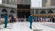 Cleaners wear protective face masks, following the outbreak of the coronavirus, as they swipe the floor at the Kaaba in the Grand mosque in the holy city of Mecca, Saudi Arabia March 3, 2020. REUTERS/Ganoo Essa